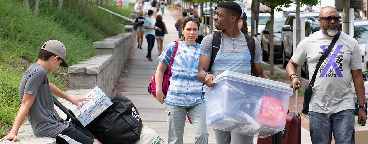 A groupd of students and parent moving stuff.