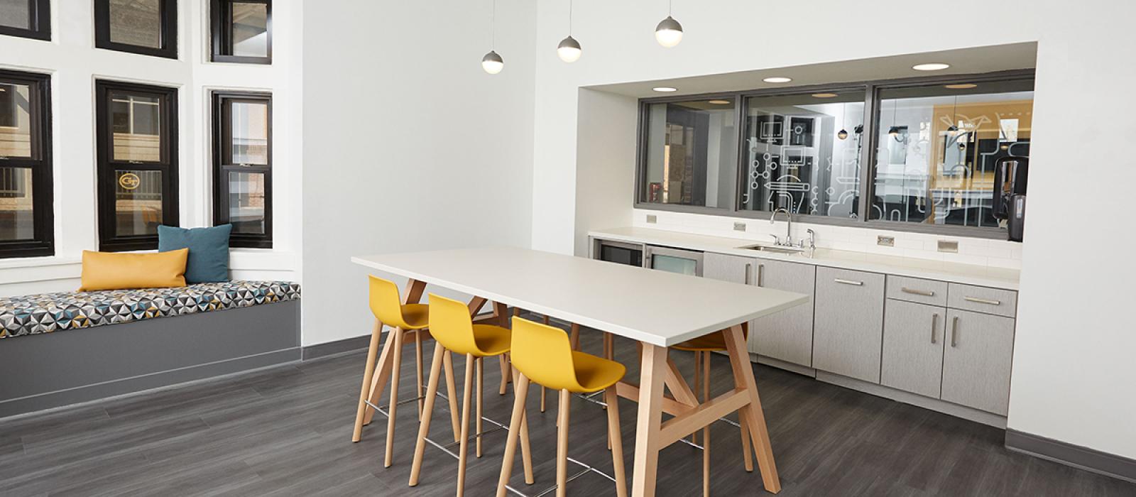 Kitchenette, long bar table and bar stools.