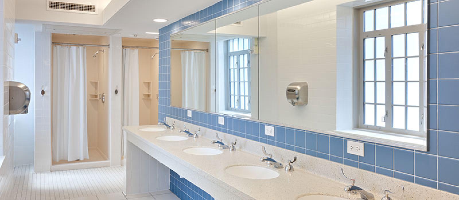 Bathroom with multiple sinks and a couple of shower stalls.