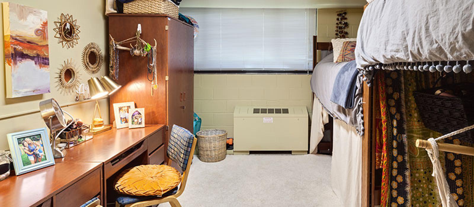 Bedroom with a desk, wardrobe, decorated with photos, blankets, lamps, etc.