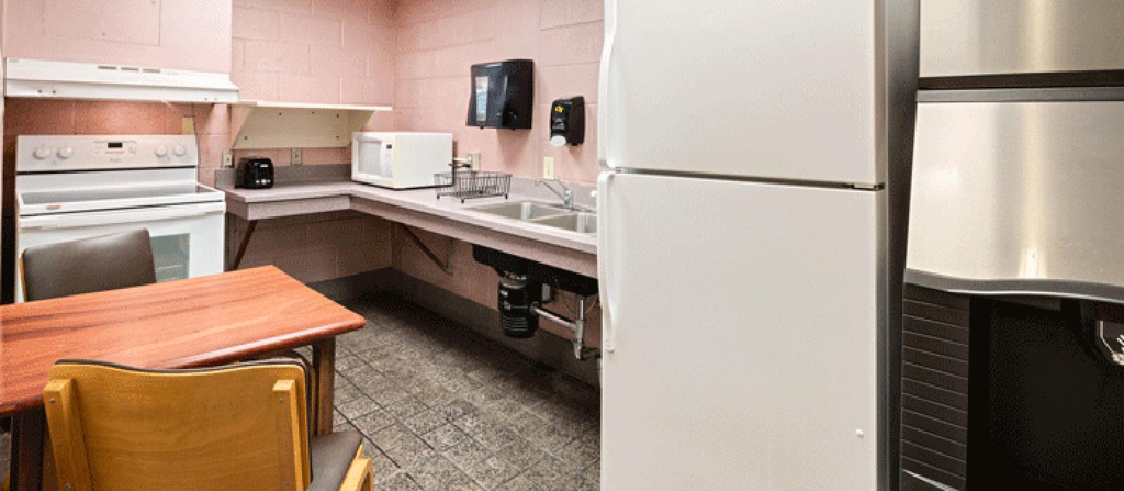 Kitchen with appliances. A table with chairs in the corner.