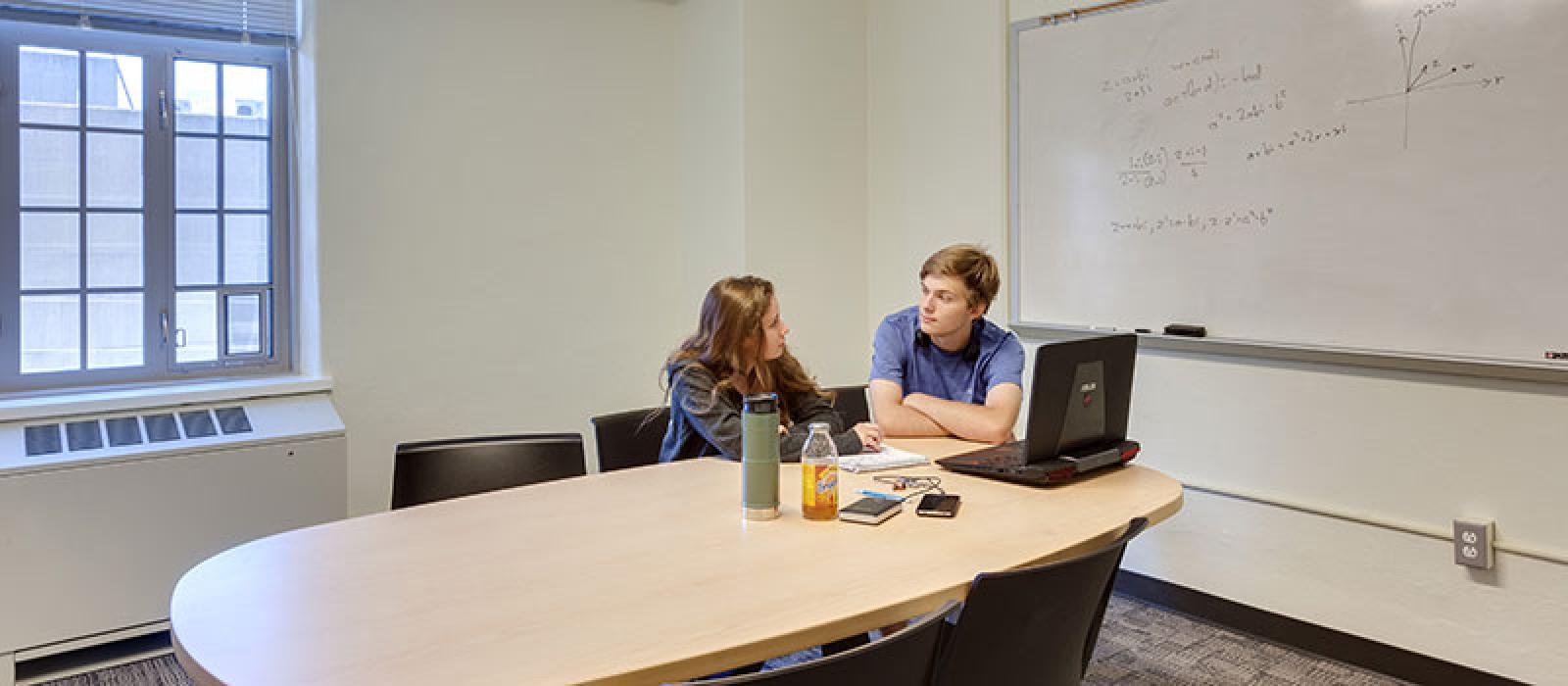 A young man and a young woman studying in the Glen study room. 