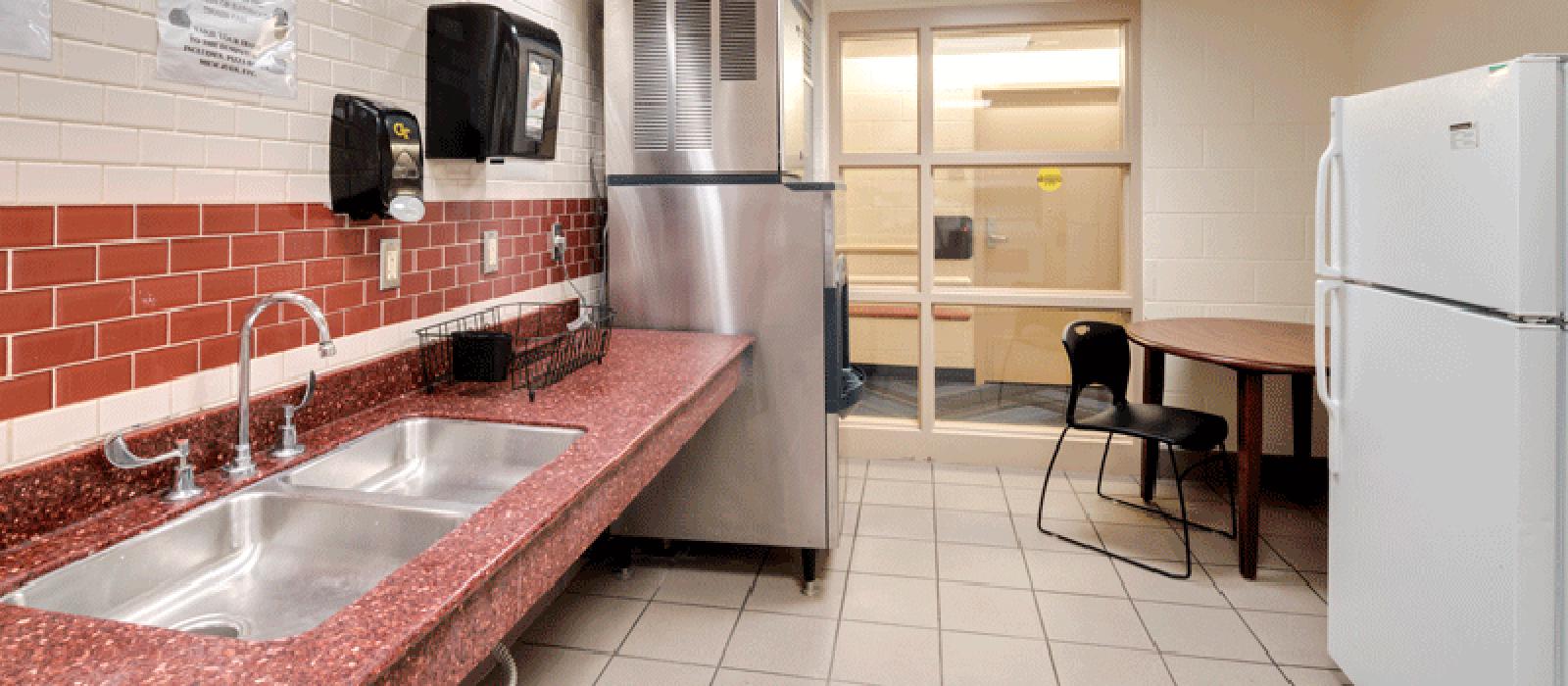 Kitchen with appliances, and a table with chairs.