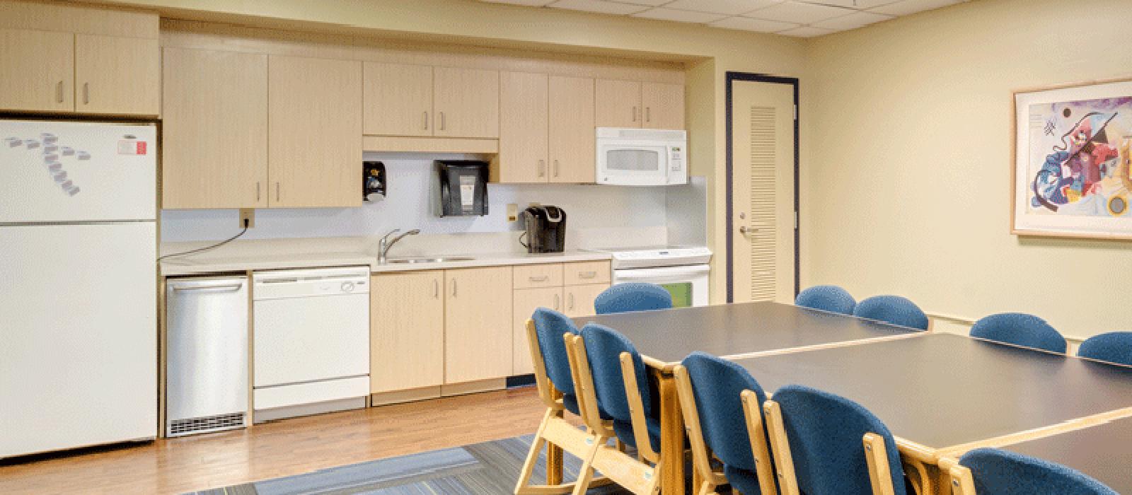 Kitchen with appliances, and a table with chairs.